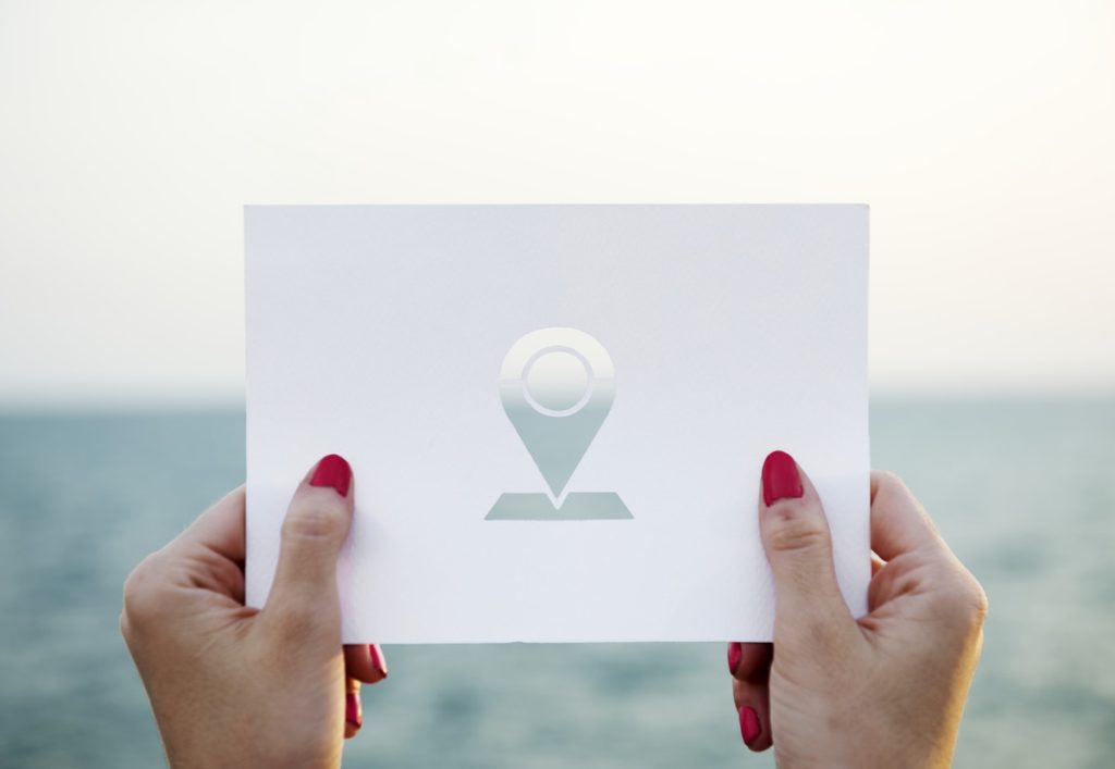 female hands holding a location marker